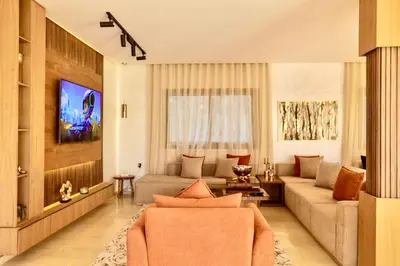 a living room with a couch and a tv at *Villa de luxe à Marrakech, vue sur les montagnes* in Marrakech