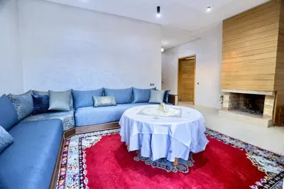 a living room with a blue couch and a table at *Villa de luxe à Marrakech, vue sur les montagnes* in Marrakech