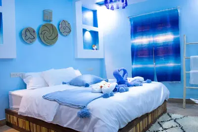 a blue bedroom with a bed with stuffed animals on it at Ecolodge Aroma Dades in El Hart