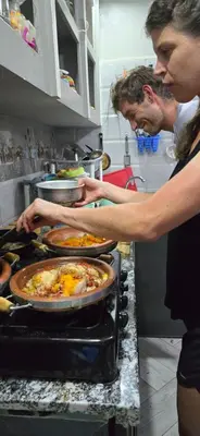 two people standing in a kitchen preparing food at Ecolodge Aroma Dades in El Hart
