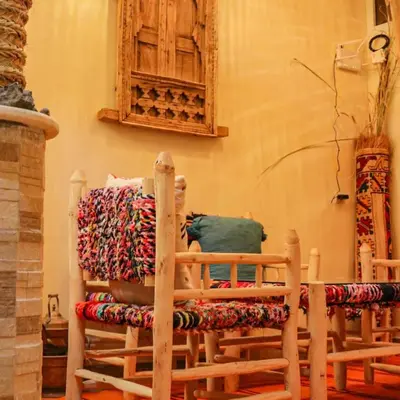 a room with two wooden chairs with pillows on them at Ecolodge Aroma Dades in El Hart
