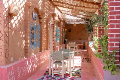 a patio with tables and chairs in a building at Ecolodge Aroma Dades in El Hart