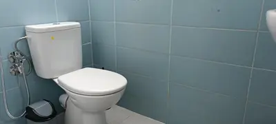 a bathroom with a toilet and a blue tile wall at Fes Panoramic Luxury Apartments in Fès