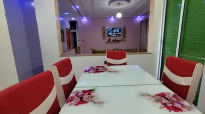 a table and chairs in a room with a television at Fes Panoramic Luxury Apartments in Fès