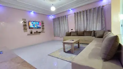a living room with a couch and a tv at Fes Panoramic Luxury Apartments in Fès