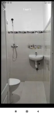 a white bathroom with a sink and a toilet at Familles avec bébé in Fès