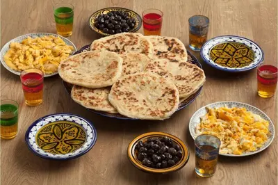 a wooden table topped with plates of food and drinks at Familles avec bébé in Fès