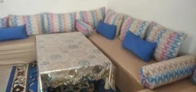 a couch with blue pillows in a living room at Familles avec bébé in Fès