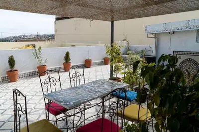 a patio with a table and chairs and plants at Dar Benjelloun in Fès