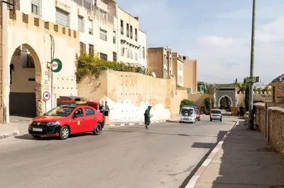 a red car parked on the side of a street at Dar Benjelloun in Fès