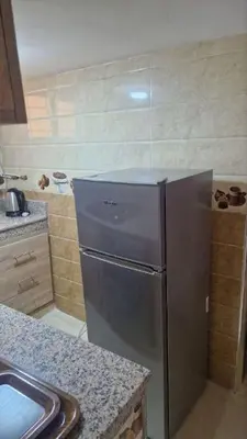 a kitchen with a stainless steel refrigerator and a sink at Dar Benjelloun in Fès