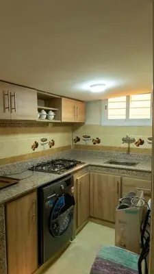a kitchen with wooden cabinets and a stove top oven at Dar Benjelloun in Fès