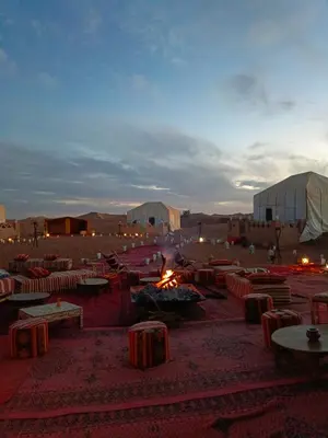 a desert with tables and tents in a field at Stay under millions of stars deep in the desert in El Gouera