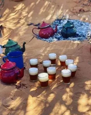 a group of glasses of beer on the ground at Stay under millions of stars deep in the desert in El Gouera