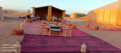 a group of chairs and a table in the desert at Stay under millions of stars deep in the desert in El Gouera