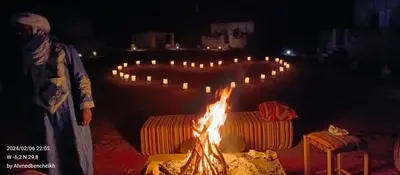 a long row of candles are lit up at Stay under millions of stars deep in the desert in El Gouera