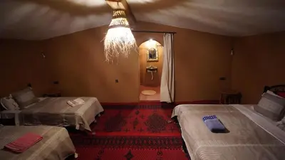 a room with two beds and a chandelier at Mhamid Nomad Camp in Mhamid