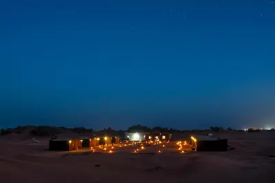 a group of tents in the desert at night at Mhamid Nomad Camp in Mhamid