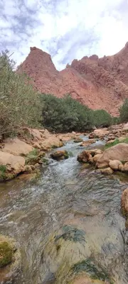 a river in the middle of a canyon with mountains at Gorges View Dades in Tamellalt