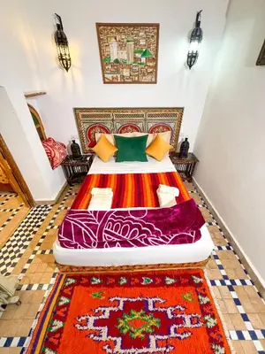 a bedroom with a bed with a colorful bedspread at Dar Houda in Fès
