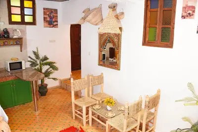 a room with a table and chairs and a mirror at Dar Houda in Fès