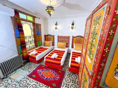 a living room with two beds and a window at Dar Houda in Fès