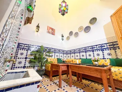 a living room with blue and white tiles on the wall at Dar Houda in Fès
