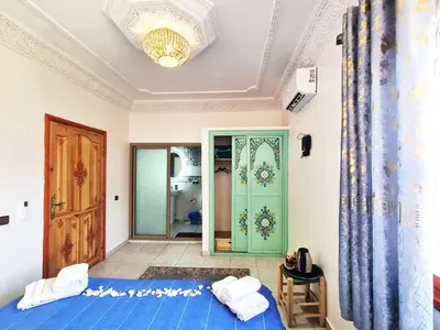 a bedroom with a blue bed and a door at Hôtel&Restaurant Villa des étoiles in Ourika