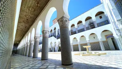 a row of columns in a building with a fountain at Youssef in Fès
