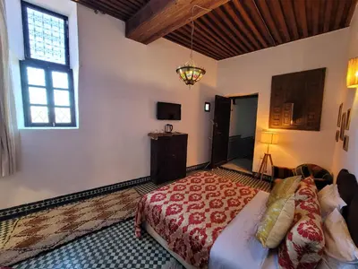 a bedroom with a large bed and a window at Youssef in Fès