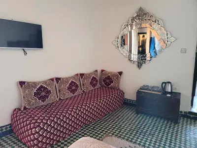 a bedroom with a couch and a mirror on the wall at Youssef in Fès