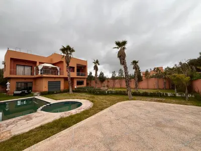a large house with a swimming pool and palm trees at Villa isouktan in Sbiti