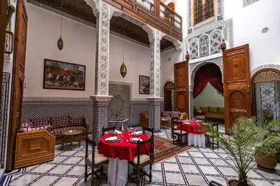 a room with a table and chairs in a building at Riad Jamal in Fès