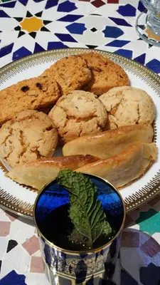 a plate of cookies on a table with a plate of dip at Riad Jamal in Fès
