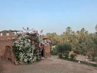 a garden with a statue on top of a building with flowers at Riad et Restaurant chez Alilouch in Nkob