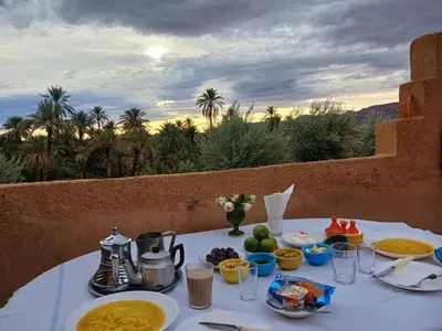 a table with plates of food on it with a view at Riad et Restaurant chez Alilouch in Nkob
