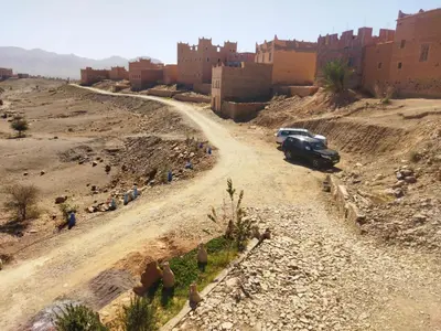a car parked on a dirt road in a village at Riad et Restaurant chez Alilouch in Nkob