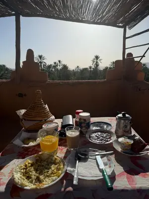 a table with plates of food and drinks on it at Riad et Restaurant chez Alilouch in Nkob