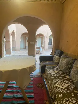 a living room with a couch and a table at Riad et Restaurant chez Alilouch in Nkob