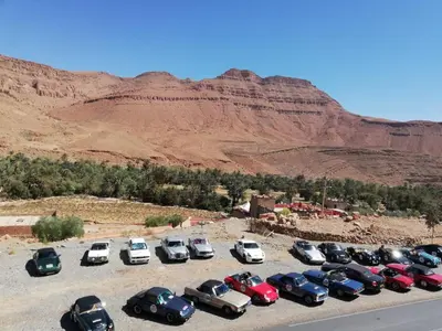 a group of cars parked in a parking lot in the desert at Palma Ziz in Aït Athmane