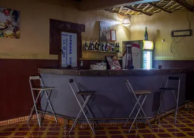 a bar with three bar stools in a room at Palma Ziz in Aït Athmane