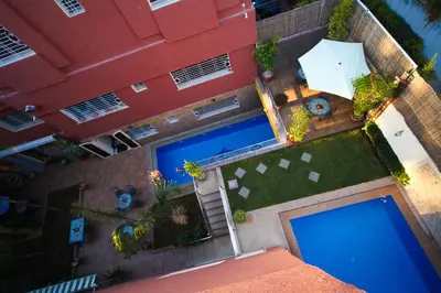 an overhead view of two swimming pools in front of a building at Riad Mimosa in Fès