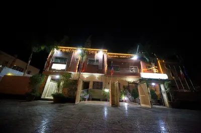 a house with lights on the front of it at night at Riad Mimosa in Fès