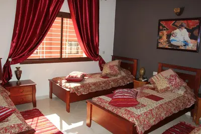 a living room with two beds and a window at Riad Mimosa in Fès