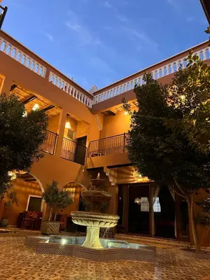 a large building with a fountain in a courtyard at Riad Tamdakhte in Aït Ben Haddou