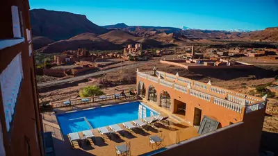 a hotel with a swimming pool in the desert at Riad Tamdakhte in Aït Ben Haddou