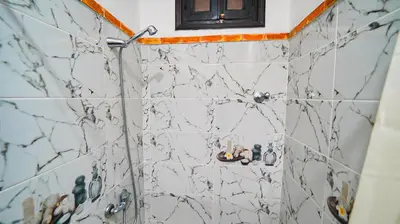 a bathroom with a shower with marble tiles at Riad Tamdakhte in Aït Ben Haddou