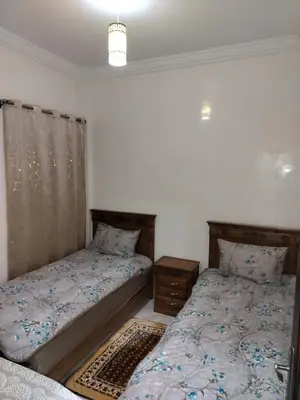 a bedroom with two beds and a night stand at Heaven of Fes in Fès