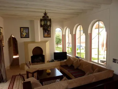 a living room with a couch and a fireplace at Exceptionnelle Villa riad avec cuisinière-Piscine chauffée-Fibre internet in Marrakech