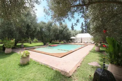 a swimming pool in a yard with trees at Exceptionnelle Villa riad avec cuisinière-Piscine chauffée-Fibre internet in Marrakech